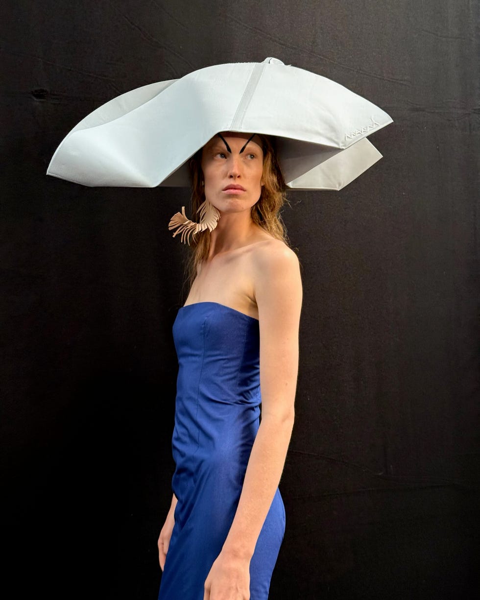 a model wears a big white hat at marni's spring 2025 show