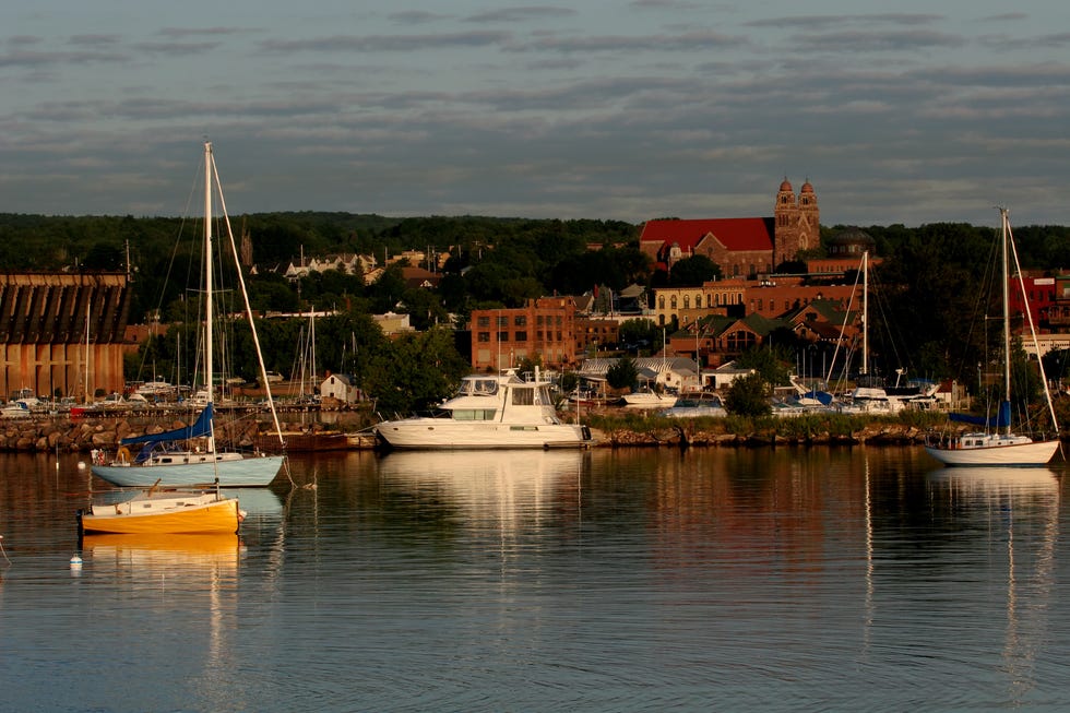 a harbor with sailboats and a town in the background