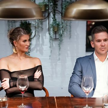 lauren and jono on marred at first sight australia sitting at a dinner table looking tense