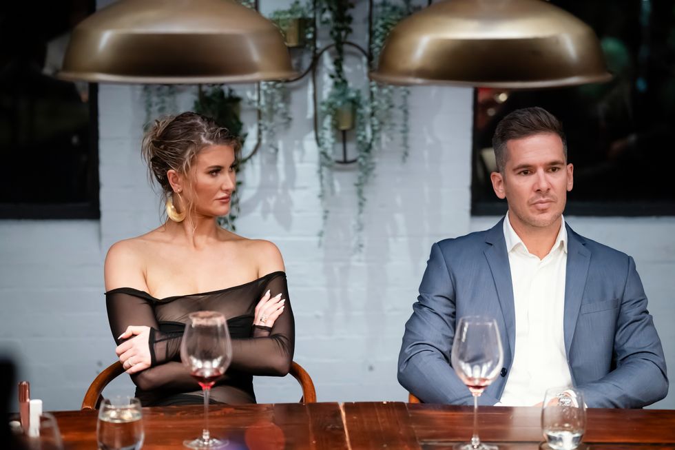 Lauren y Jono en Marred at First Sight Australia sentados en una mesa luciendo tensos