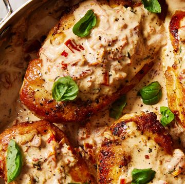 chicken breasts in a skillet with a creamy sun dried tomato sauce