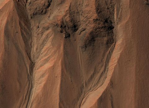 Aan de rand van de krater Hale in het zuiden van Mars zijn geulen te herkennen Op aarde ontstaan dit soort bodemvormen vaak door de invloed van vloeibaar water