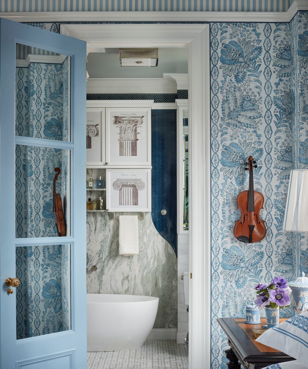 bathroom with blue and white wallpaper and a white freestanding tub