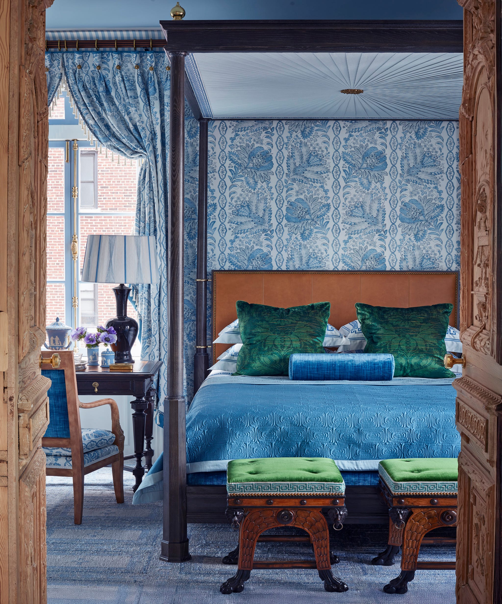 bedroom featuring a wood fourposter bed, blue bedroom, and blue and white wallpaper