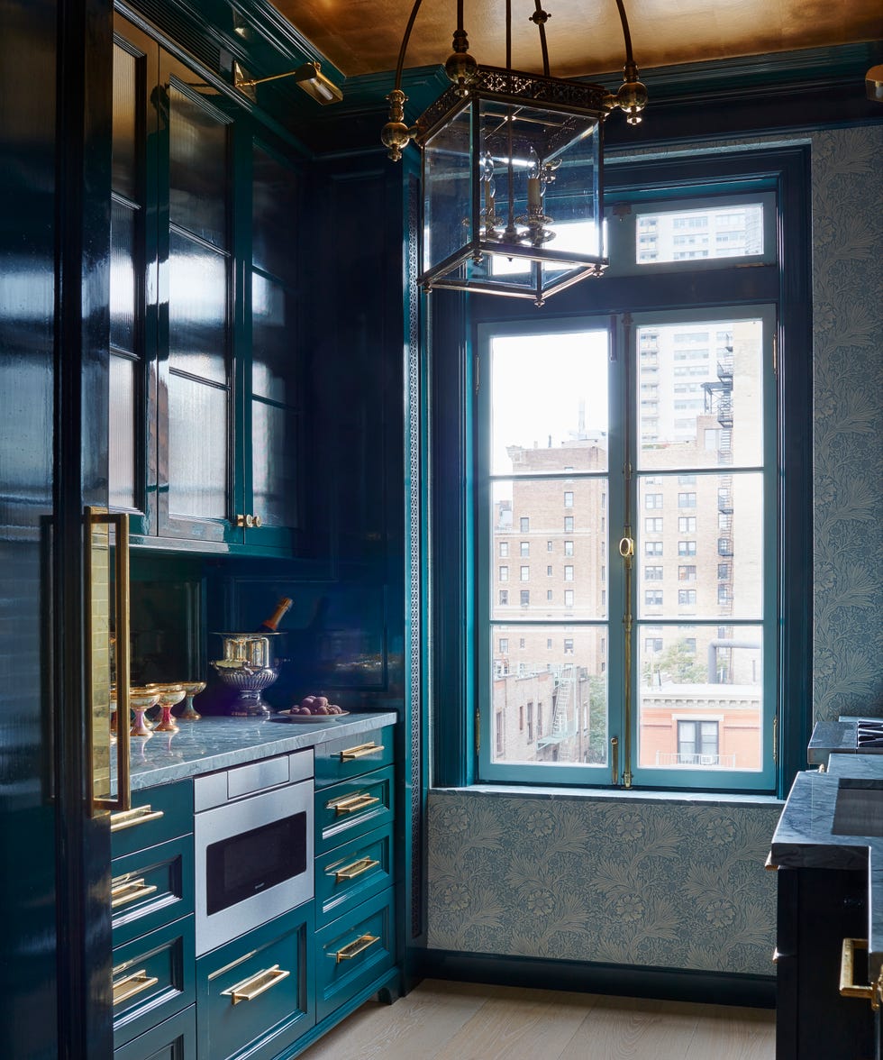 small kitchen with dark blue cabinetry and brass pulls