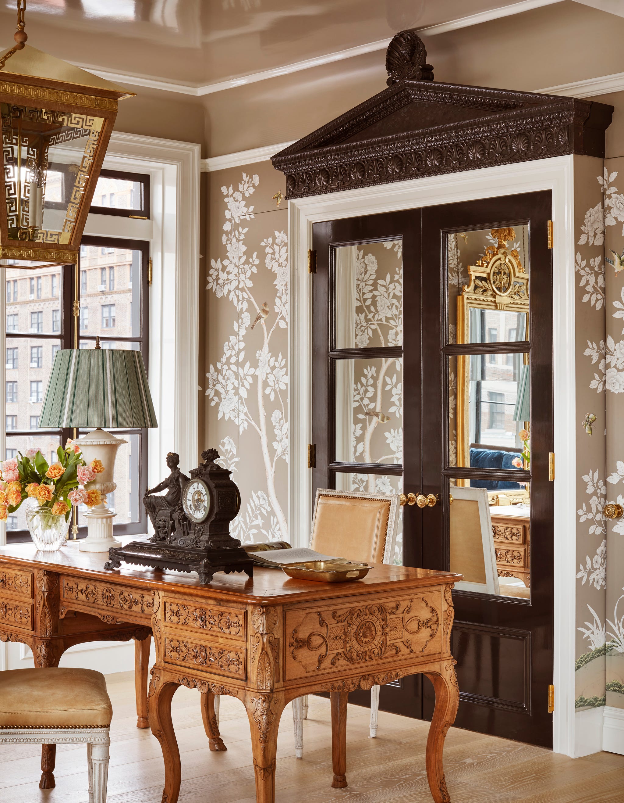 study with large wood desk and french doors behind it
