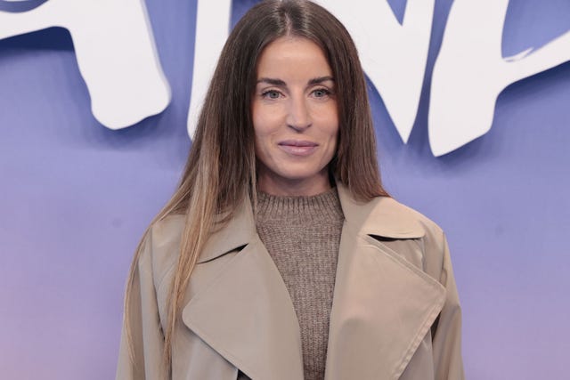 individual wearing a beige coat over a knitted sweater