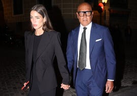 la pareja, con semblante serio, y vestidos de oscuro