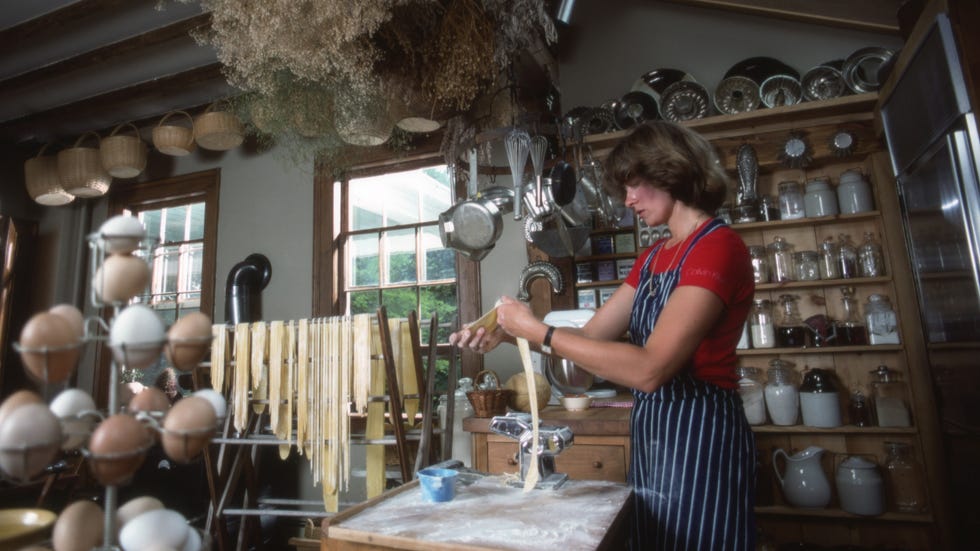 a person preparing pasta in a rustic kitchen