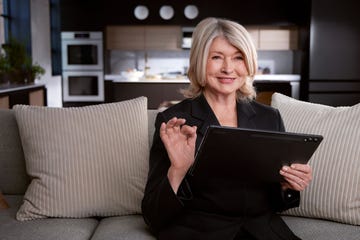 martha stewart on a couch holding a laptop