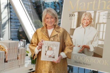 martha stewart wears a gold jacket and poses for a photo while holding her new cookbook