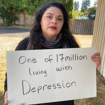 martha aguilar who lives with depression carrying white sign sharing the statistic one of 17 million living with depression