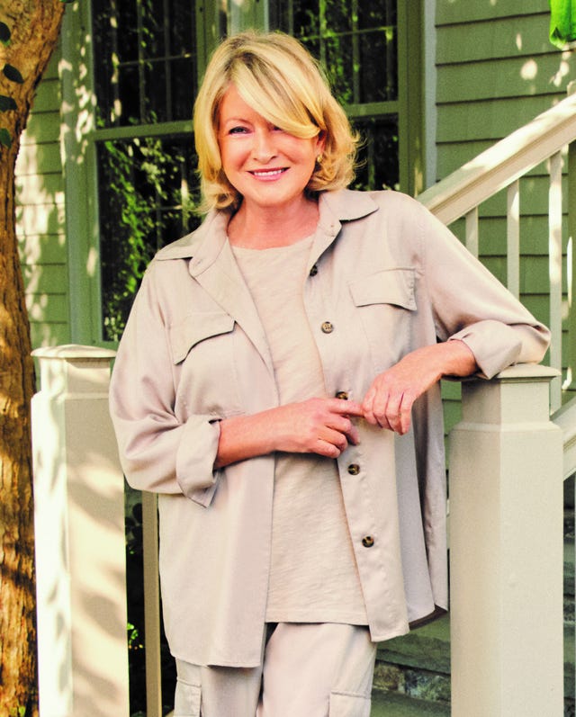 person leaning against a porch rail in a casual outfit