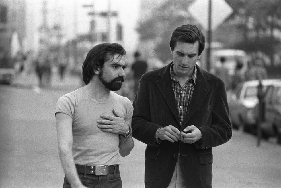 a black and white photo of martin scorsese talking to robert de niro on a new york city street