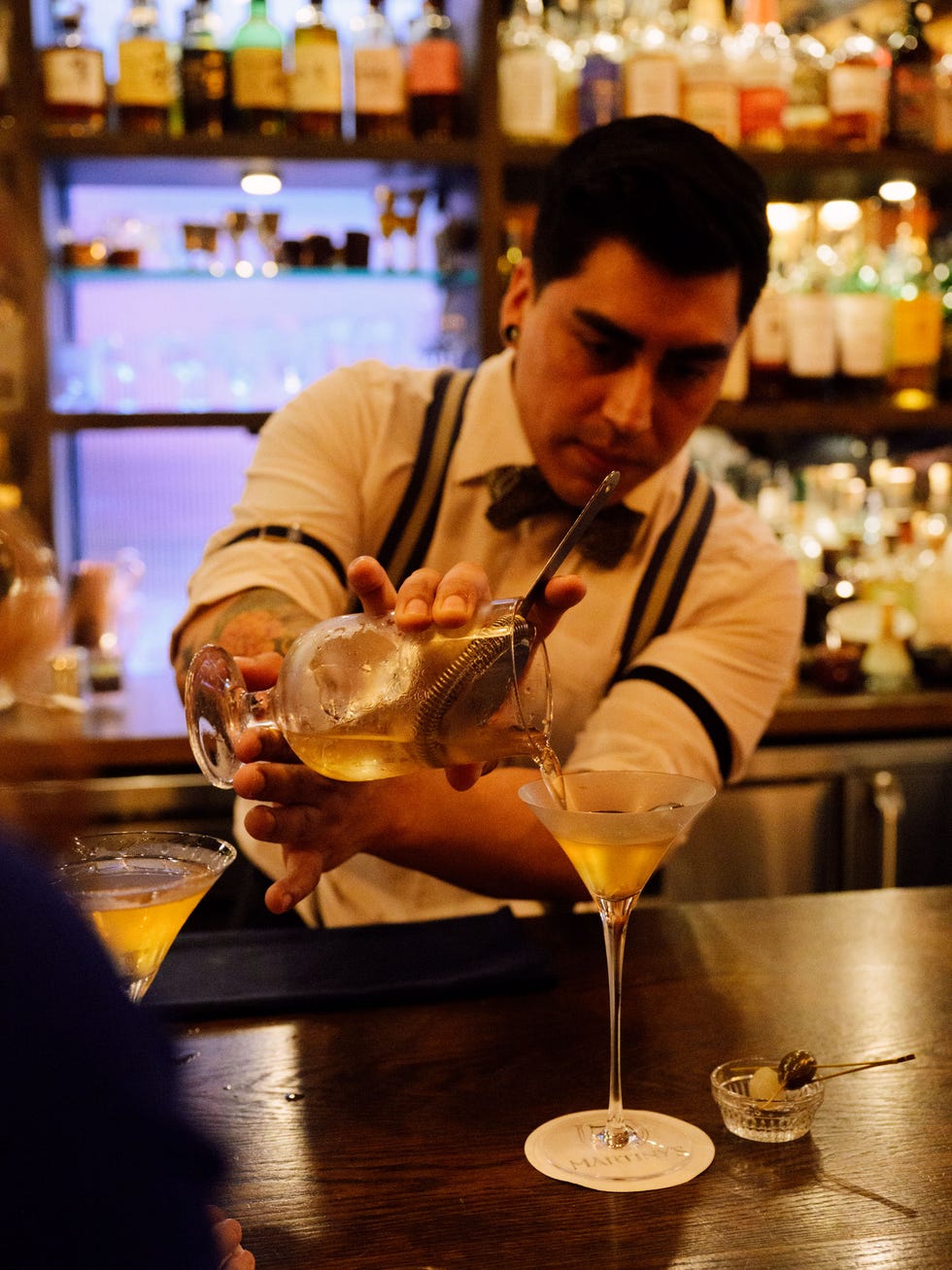 a man pouring a drink into a glass