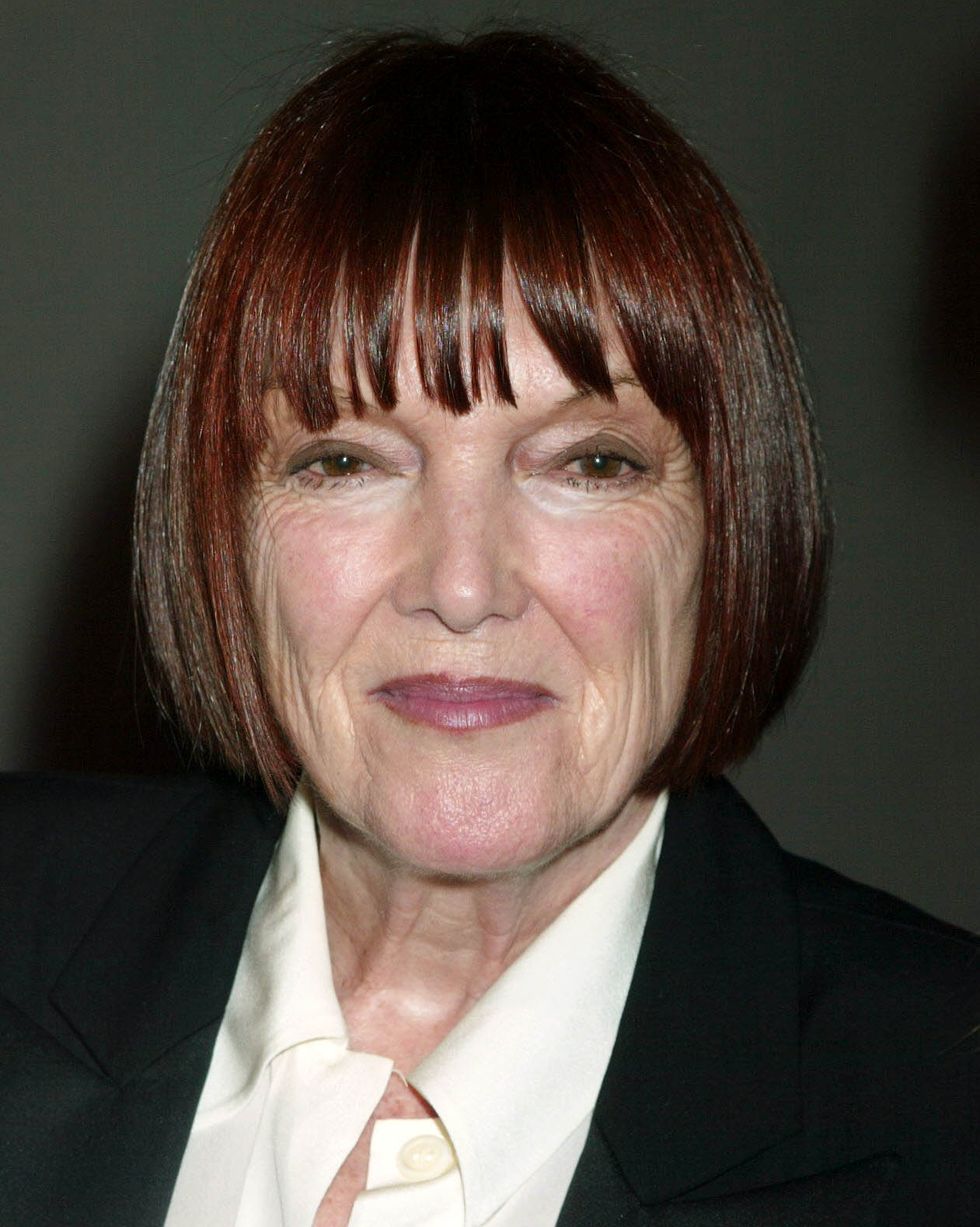 fashion icon mary quant smiles at the camera, sporting her signature vidal sassoon bob, a dark jacket and a cream colored collared shirt