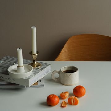 a table with a candle and a cup of coffee