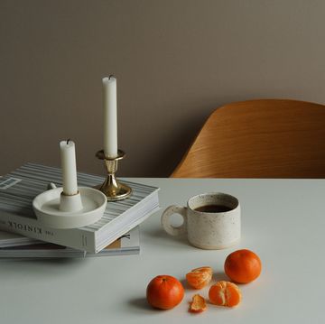 a table with a candle and a cup of coffee