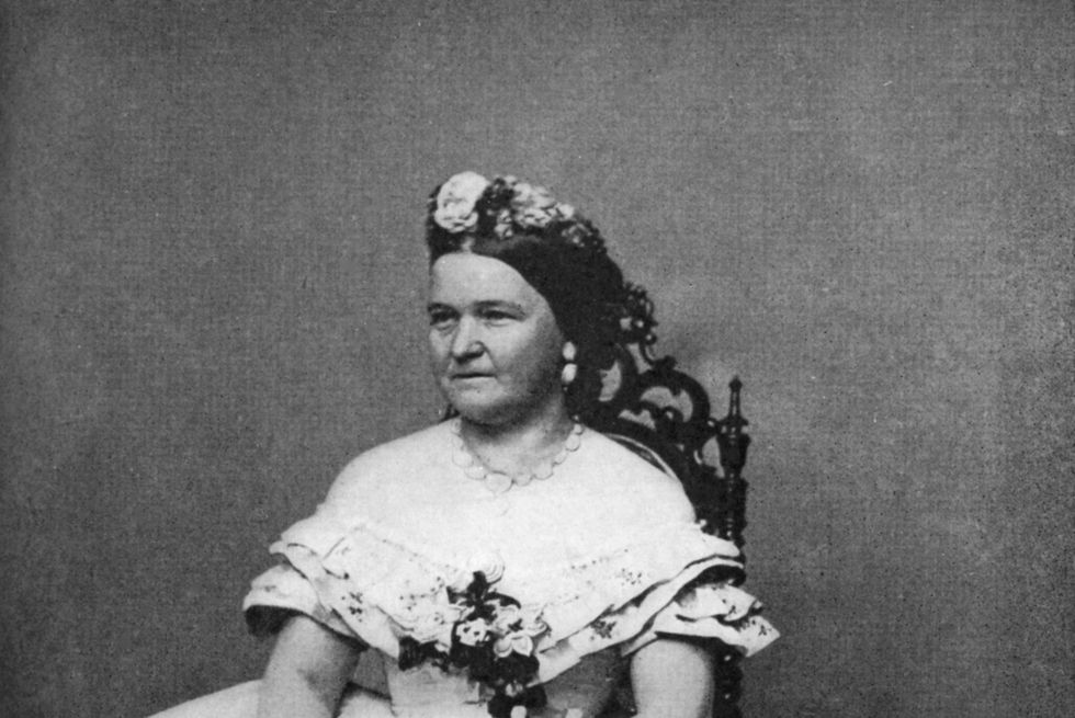 mary todd lincoln sitting in a chair and holding flowers for a photo