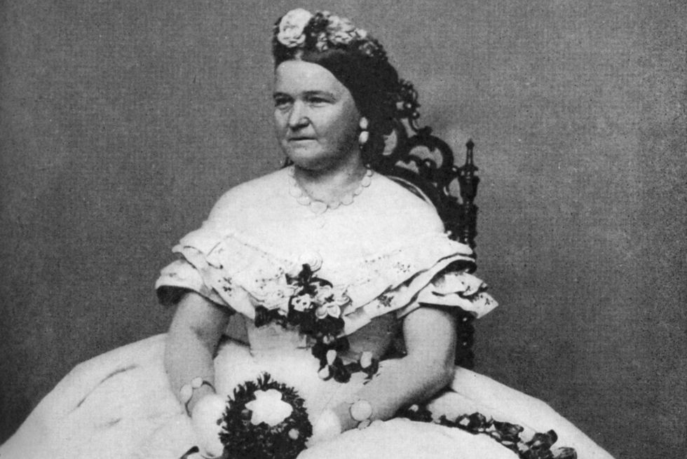 mary todd lincoln sitting in a chair and holding flowers for a photo