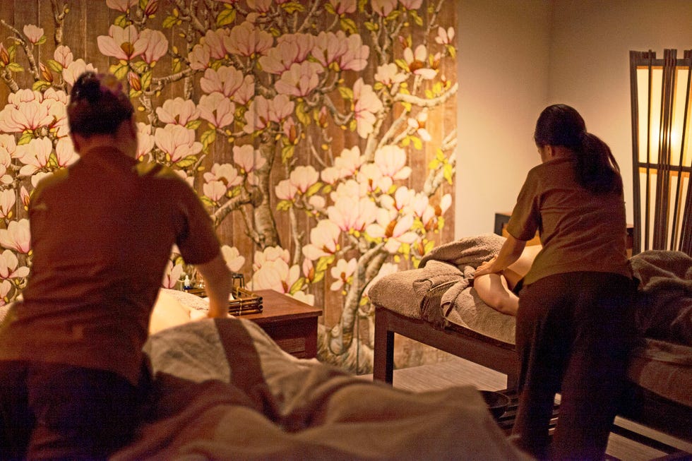 a group of people sitting in a room with a large bouquet of flowers