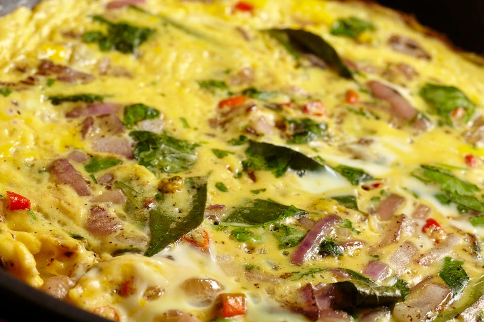 a masala omlette being fried in a pan close up
