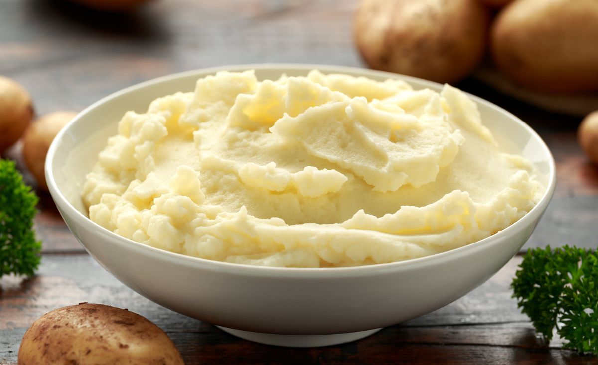 mashed potatoes in white bowl on wooden rustic table 
healthy food