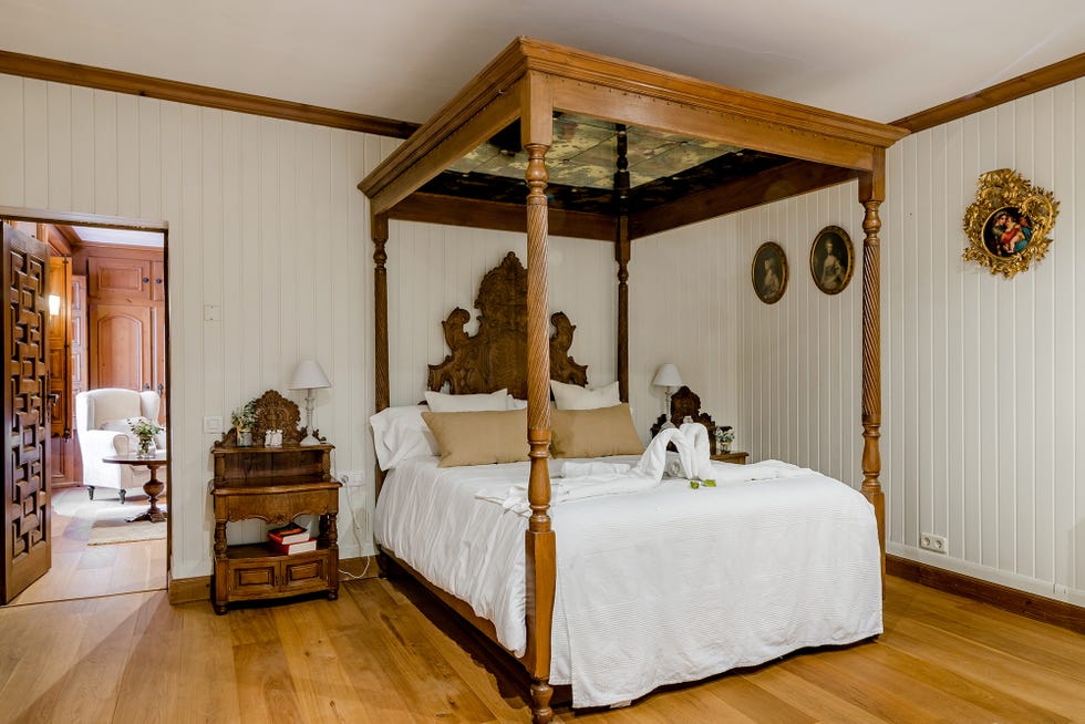 cama con dosel de madera en dormitorio de estilo señorial