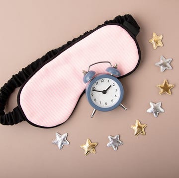 mask for sleep and alarm clock near itgolden and silver stars aroundcircadian rhythms and healthy sleep concept