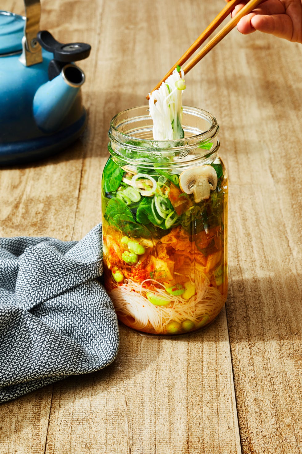 noodle soup with edamame, mushrooms, and spinach in a mason jar