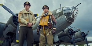 callum turner and austin butler star looking up and off camera while standing in front of bomber planes in a scene from masters of the air