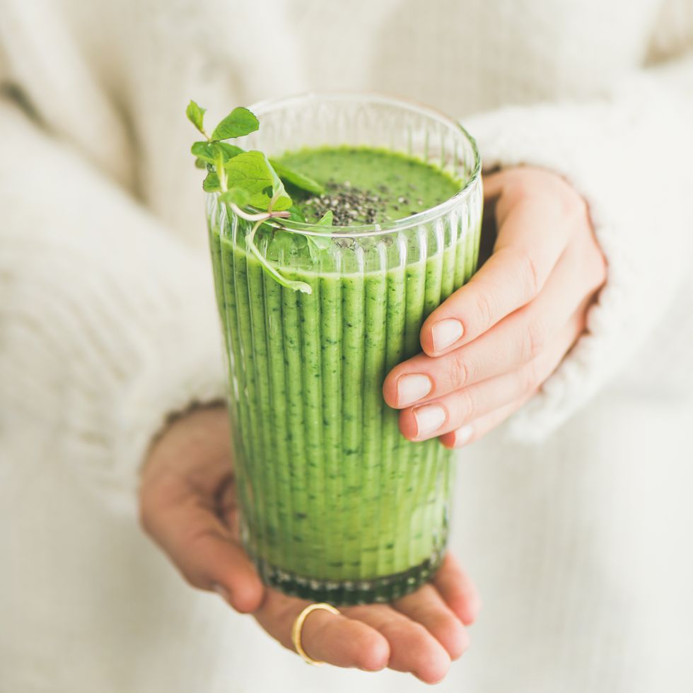 matcha smoothie with chia seeds in female hands, square crop