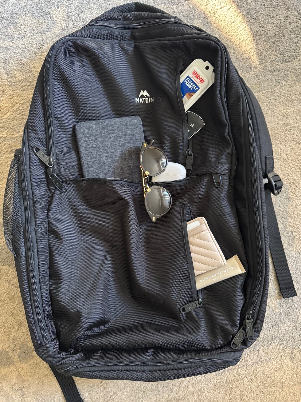 a black backpack featuring various items stored in its pockets