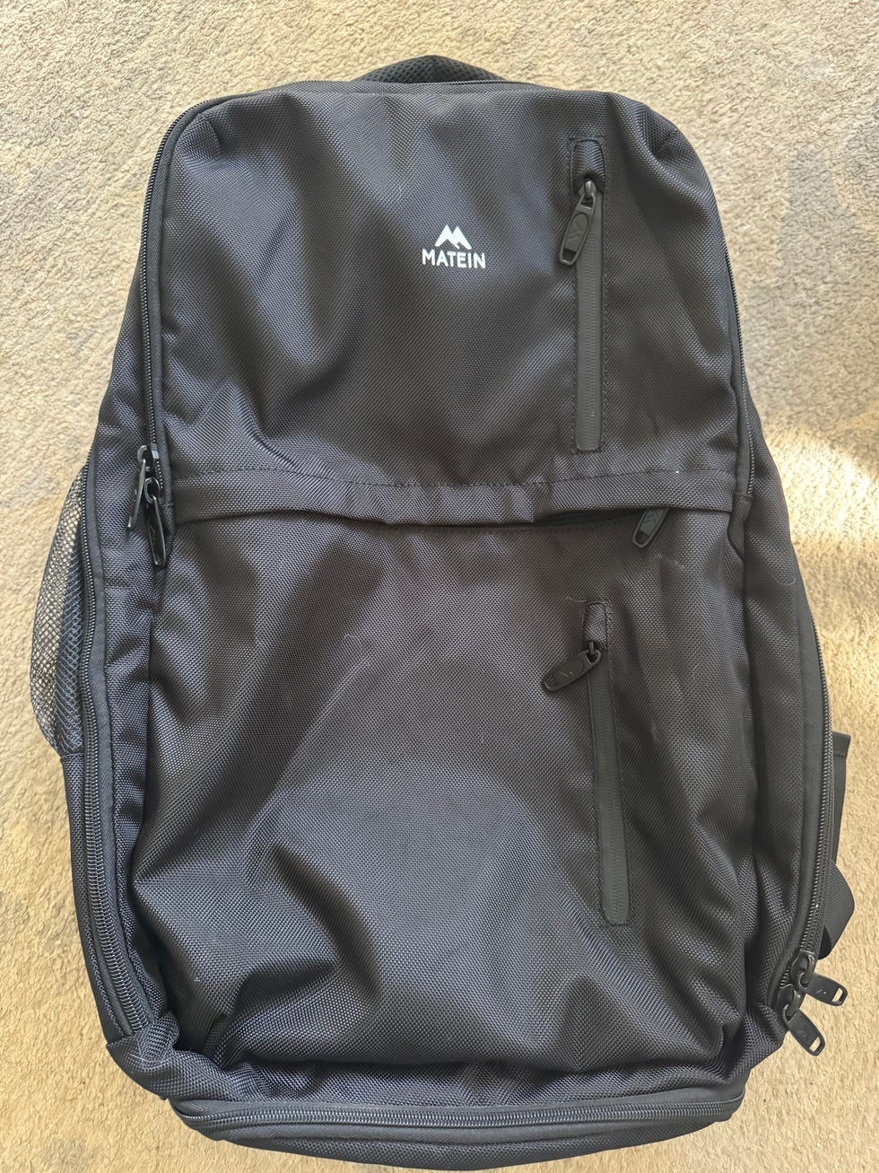black backpack with multiple zipper pockets and a logo