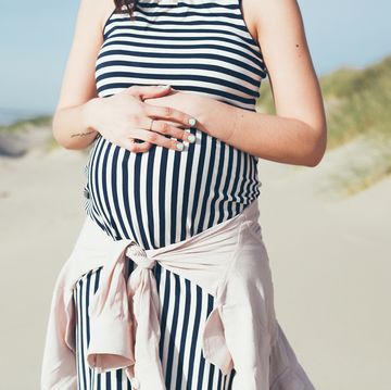 pregnant woman in striped maternity dress at beach