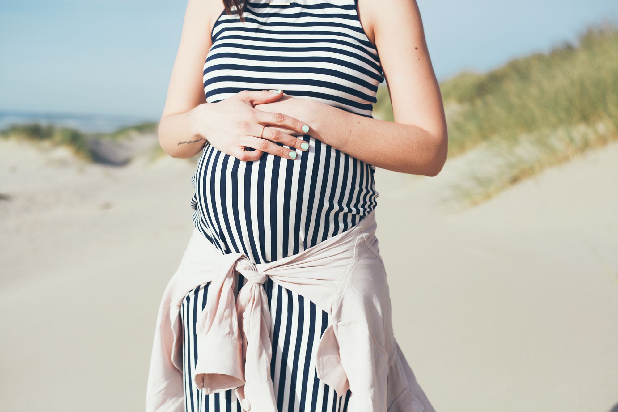 pregnant woman in striped maternity dress at beach