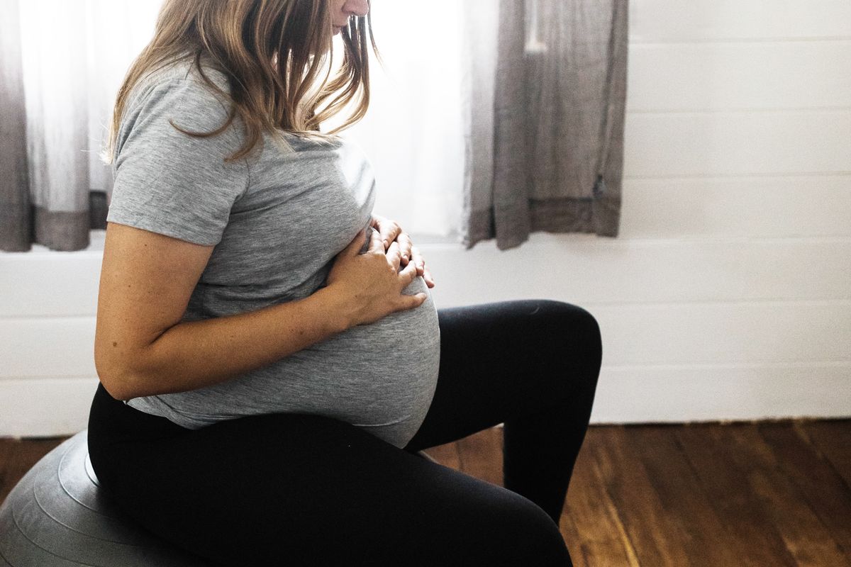 pregnant woman sitting on balance ball