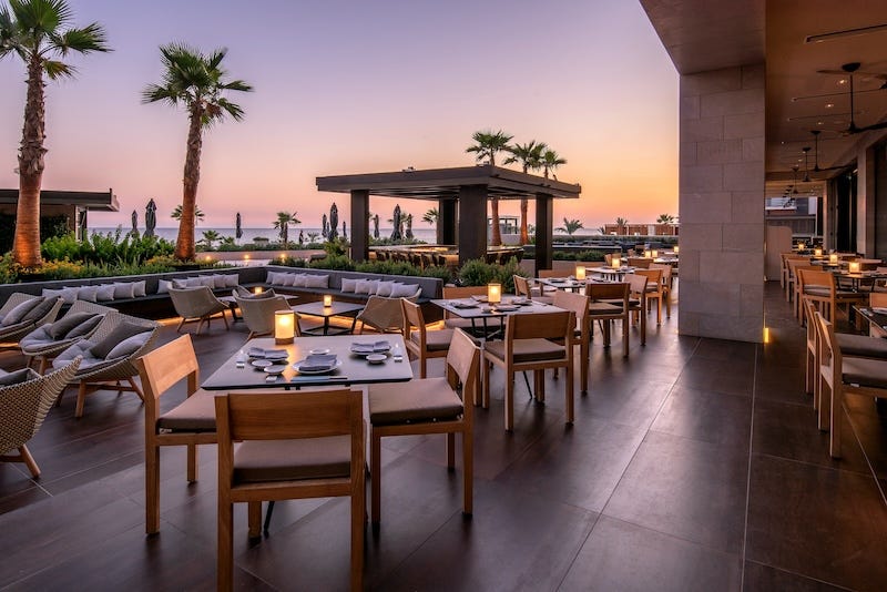 Restaurant patio with seating and sunset view