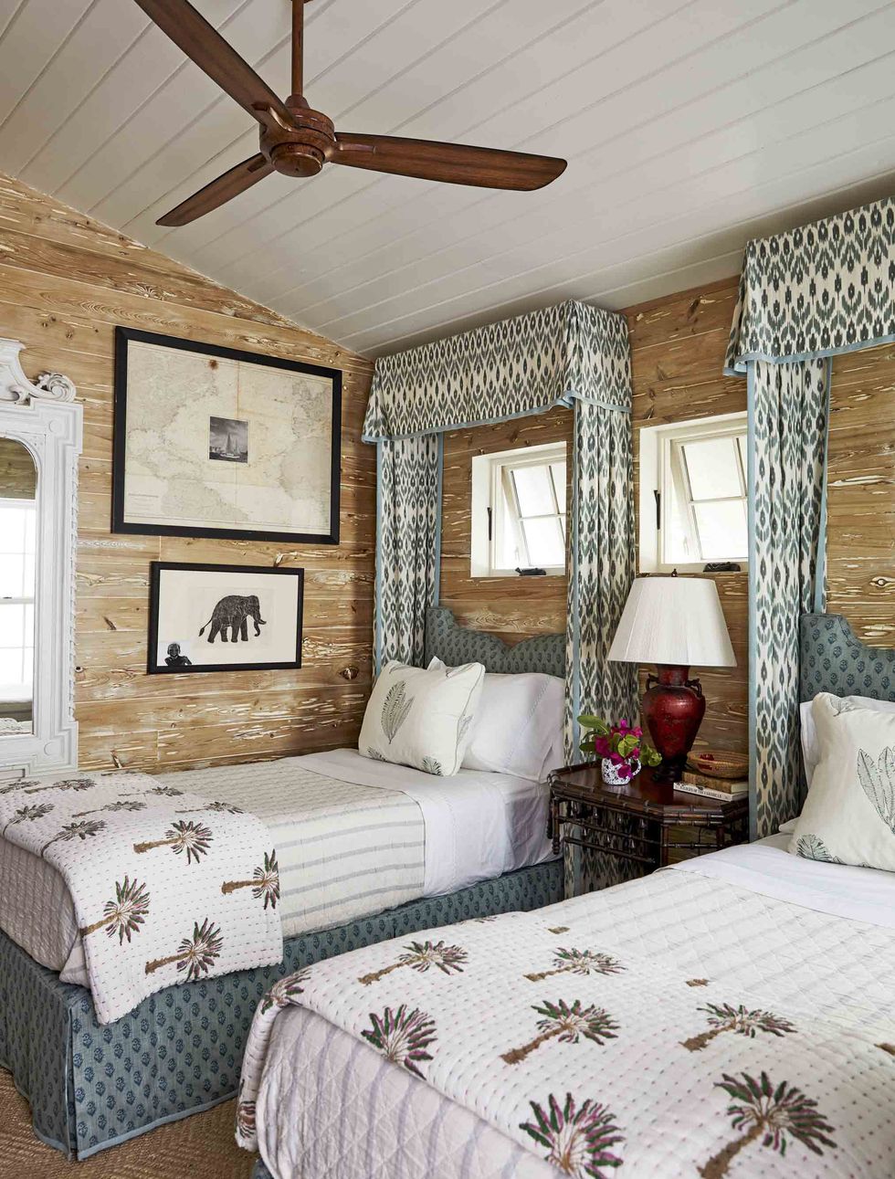 limed pecky cypress paneling envelops the walls in the guest cottage with two twin beds