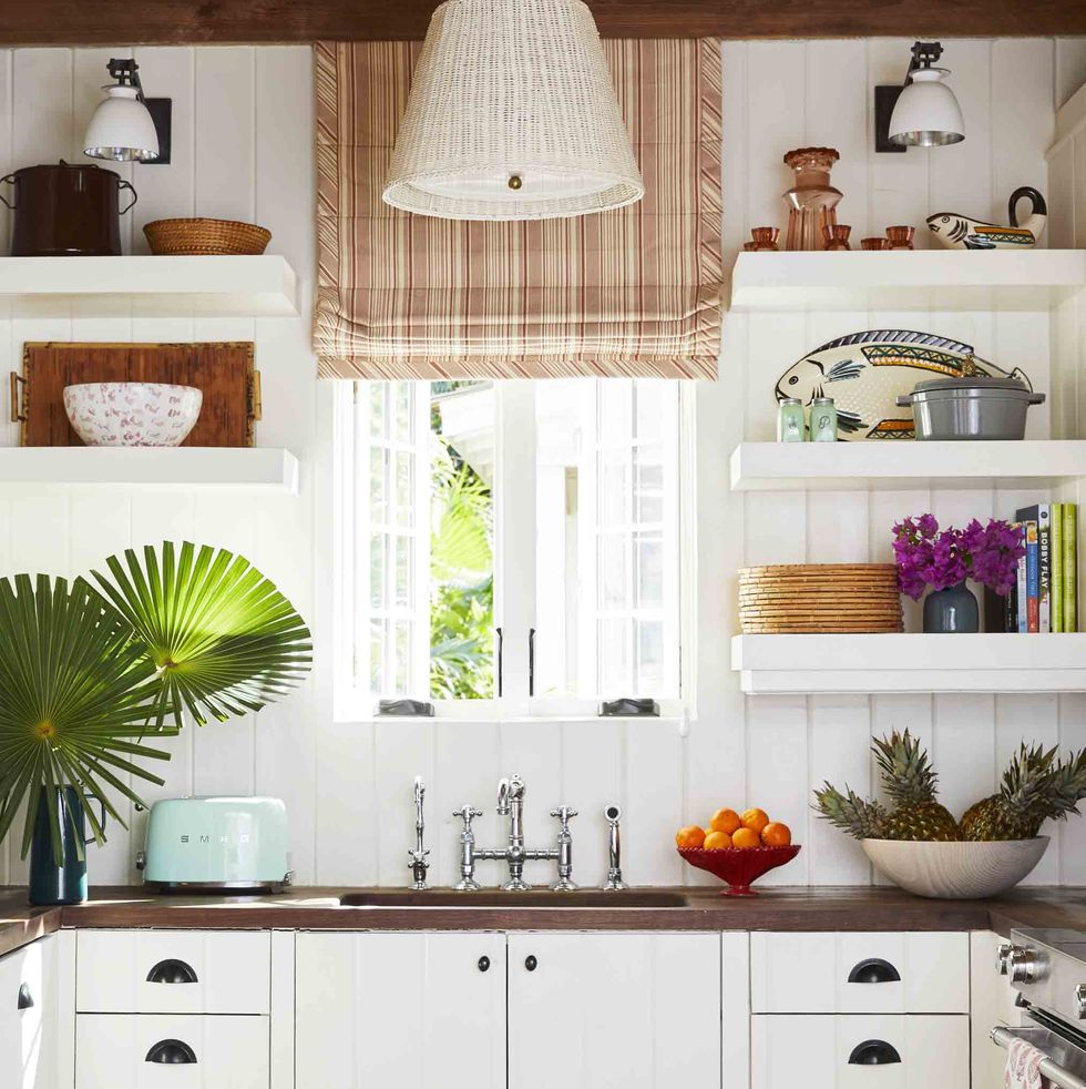mahogany countertops, abaco pine beams, and vintage wicker pendant shades ground the kitchen in organic island simplicity