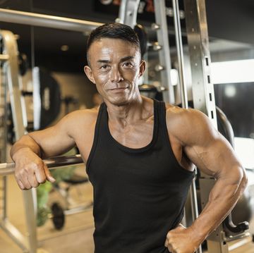 mature adult man working out at personal training gym