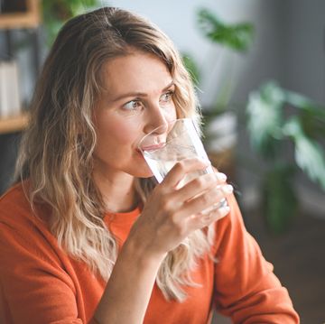 mature adult woman drinking water from a glass