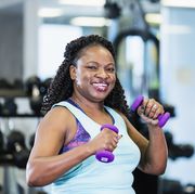 mature african american woman at gym lifting handweights