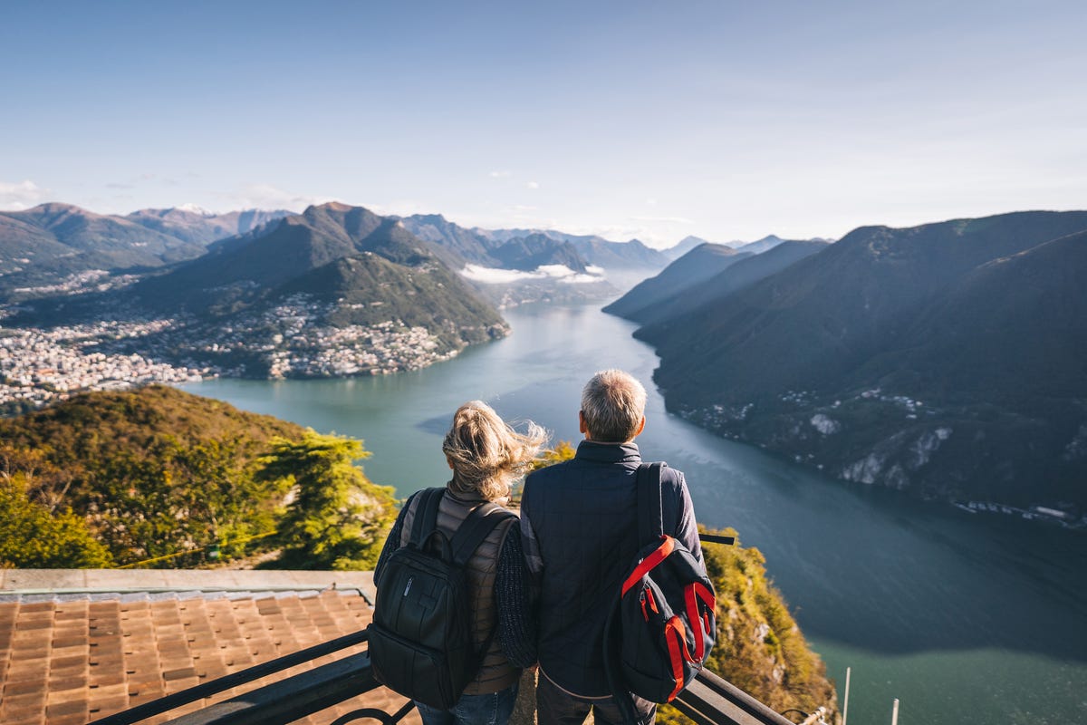 https://hips.hearstapps.com/hmg-prod/images/mature-couple-hike-above-lake-lugano-in-the-morning-royalty-free-image-1641254420.jpg?crop=0.88889xw:1xh;center,top&resize=1200:*