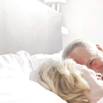 mature couple lauging in bed