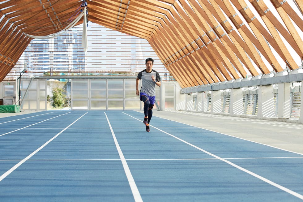 mature japanese sportsman running on track