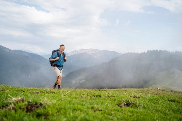 mature male backpacker hiking on mountain