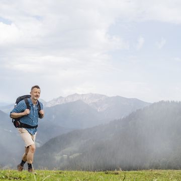 mature male backpacker hiking on mountain