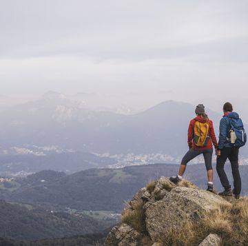 mature man and woman holding hands standing on rock