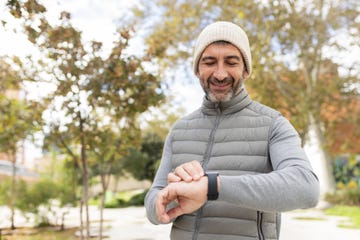 mature man checking time outdoors male wearing winter clothes looking at wrist watch copy space